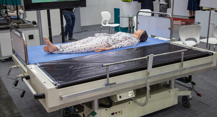 Patient dummy lying on automatic transfer hospital bed