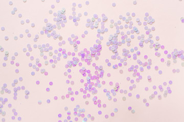 Holographic pastel glitter confetti on pink background. Creative festive backdrop