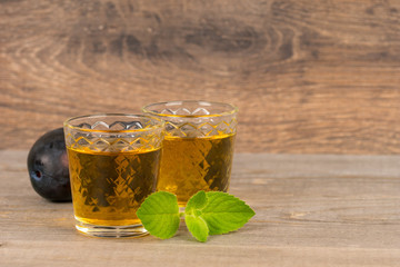 homemade sweet plum wine in glasses on wooden table