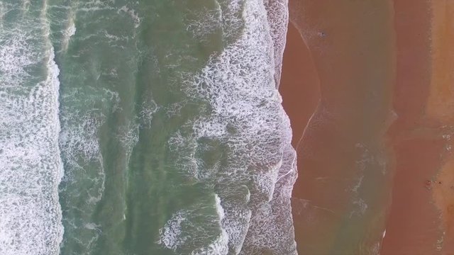 Waves rolling into the beach at Croyde Bay, North Devon in the UK.  Footage was taken using a drone directly above the beach.