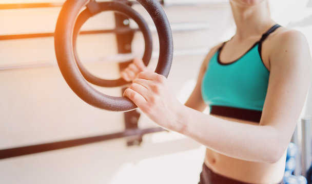 Close up woman holding gymnastic rings in the gym