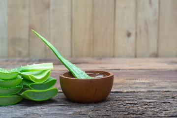 Fresh aloe vera stem slices and gel on wooden table, skin therapy concept