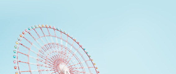 Retro colorful ferris wheel of the amusement park in the blue sky  background.