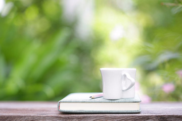 White cup and notebook at outdoor