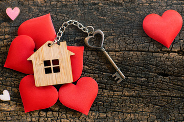 House key in heart shape with home keyring on old wood background decorated with mini heart - 281365067