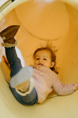 Cute little girl having fun in the slide at the playground 