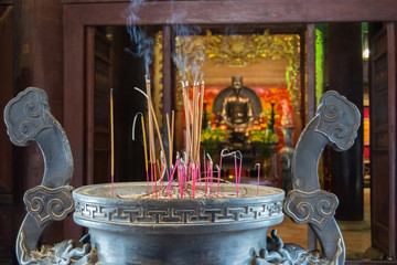 Incense Sticks burning on the three legs metal joss stick jar scale over 400 years