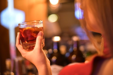 Mano de mujer con vaso whisky