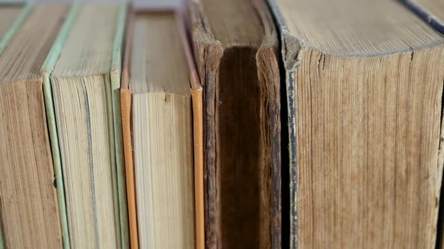 Books in a row close up slider shot, camera movement from right to left.