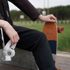 the guy is sitting with headphones and skate