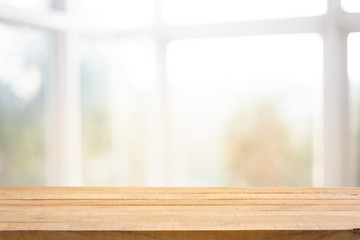 Blur background of white window glass and sky view from garden with empty of wood table.