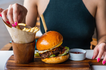 Young girl eats burger, american unhealthy calories meal. Unhealthy eating concept