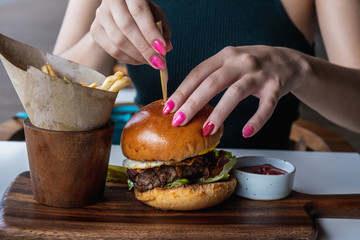 Young girl eats burger, american unhealthy calories meal. Unhealthy eating concept
