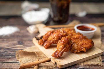Hot and spicy Korean barbeque fried chicken on wood cutting board