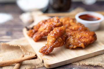 Hot and spicy Korean barbeque fried chicken on wood cutting board