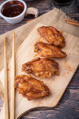 Hot and spicy Korean barbeque fried chicken on wood cutting board