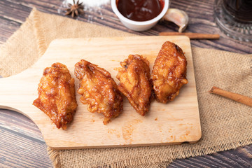 Hot and spicy Korean barbeque fried chicken on wood cutting board