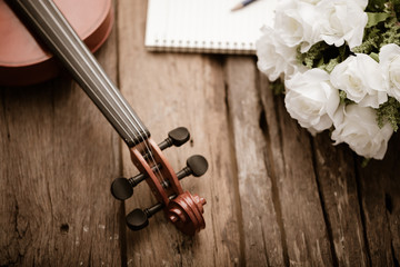 Fototapeta premium Close-up shot violin orchestra instrumental with vintage tone processed over wooden background select focus shallow depth of field