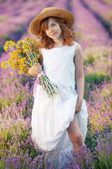 Child girl in a field with flowers. 