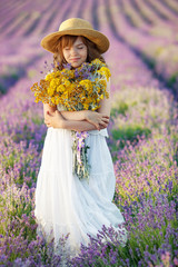 Child girl in a field with flowers. 