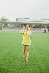 Obraz premium Young girl student having fun on grass field in the afternoon in campus