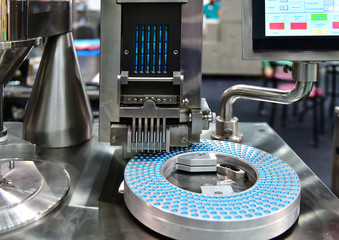 Blue capsule medicine pill production line, Industrial pharmaceutical concept.banner size