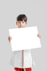 Indian / Asian little boy in ethnic wear and showing blank Signboard 