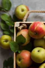 Ripe green and red apples in wooden box.