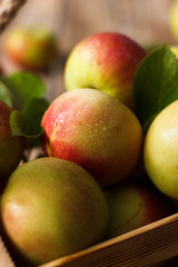 Ripe green and red apples in wooden box.