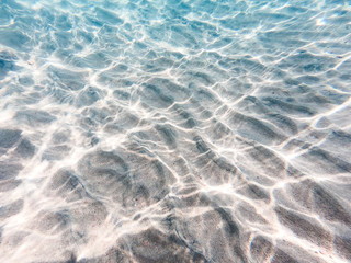 underwater background with sandy sea bottom. Beautiful texture of the sea and ocean water. Pure water texture.