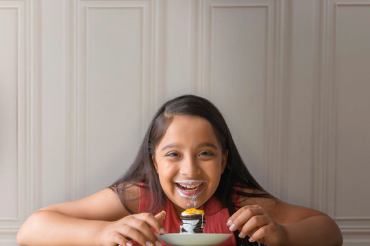 Smiling girl with milk mustache eating a stack of cream biscuit pie