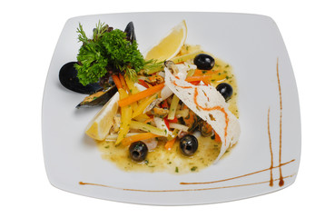 Salad from vegetables and seafood with olives and lemon on a square plate on a white isolated background