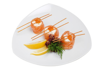 Roasted salmon and vegetablesDish of salmon with sauce on a plate with lemon and greens on white isolated background
