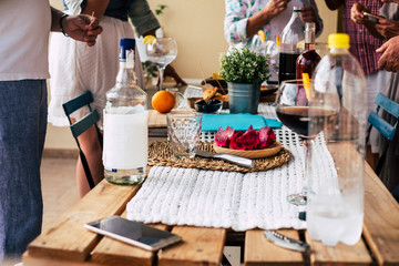 Group of unrecognizable people mixed ages have fun together in home celebration with cocktails and fruit food - concept of friendship and family during dinner party or friendly time