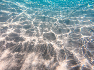 underwater background with sandy sea bottom. Beautiful texture of the sea and ocean water. Pure water texture.