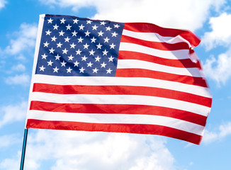 American flag waving in the wind against blue sky