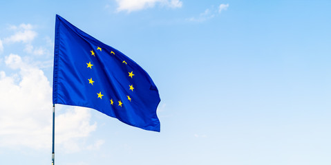 European Union flag against blue sky waving