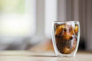 cola drinks with ice in the glass on table at home background with copy space