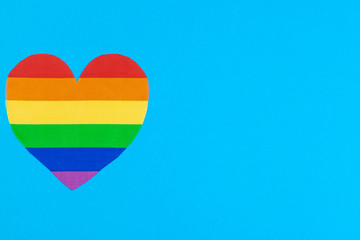 Rainbow paper heart on paper background top view