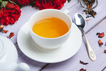 Cup of green tea on table with fresh peony flowers