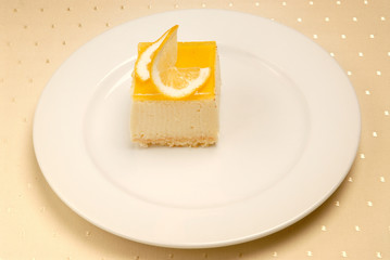 Slice of Lemon Cheesecake on white plate on the table