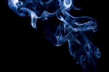 Obraz premium Blue incense smoke on a black background.