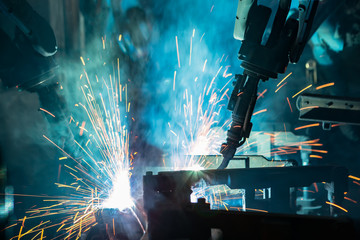 Team industrial robot are welding in factory