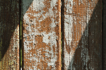 Wooden fence with peeling paint an sunspot texture