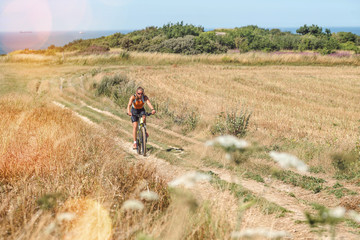 pretty young woman doing mountain bike in the summer sun