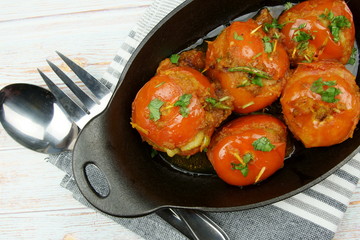 Tomatoes stuffed with a spicy mixture of mashed potatoes in an Indian gravy or curry.