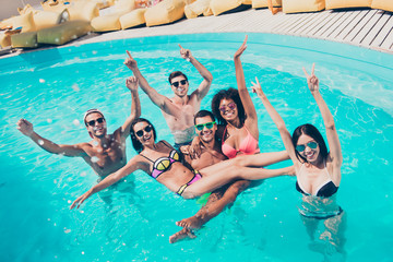 Photo of six multinational friends fooling around in water enjoying best company and perfect sunny...