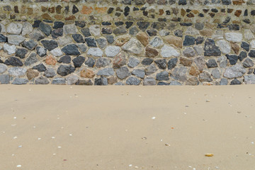 sand with stone wall on the beach