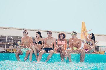 Portrait of funky students having brunet hair wearing eyewear eyeglasses sit laughing enjoying outdoors in resort