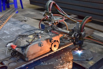 Worker cutting metal plate by Gas Cutting Machine in the workshop.